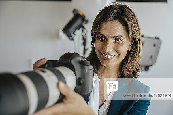 Surprise photographer looking at digital camera in studio