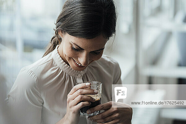 Smiling businesswoman holding coffee cup in office