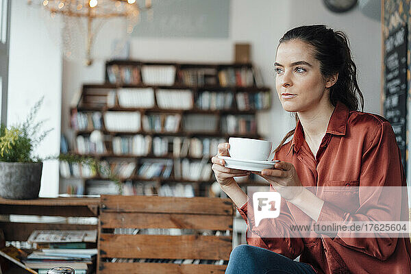 Thoughtful woman having coffee in cafe