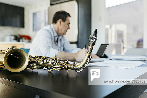 Saxophone kept by musician sitting at table