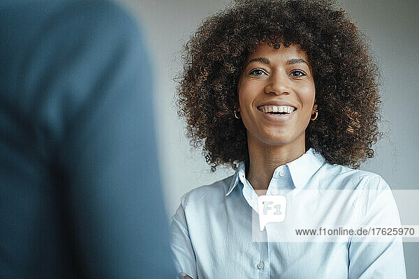 Smiling businesswoman by colleague at work place