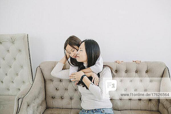 Mother embracing daughter in living room
