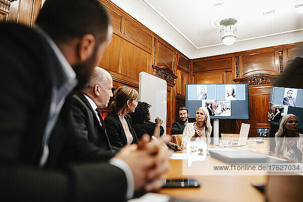 Female financial expert discussing with colleagues in conference at office