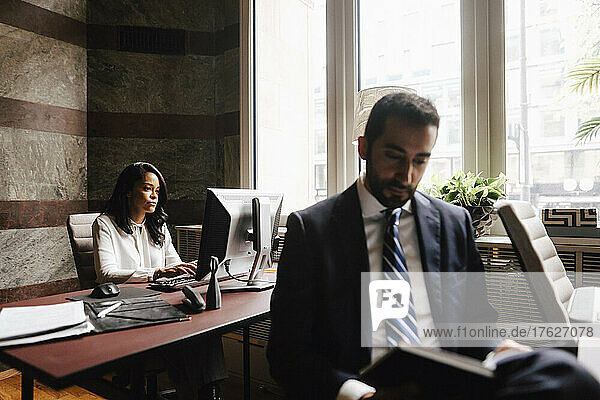 Male and female financial advisors working at law office