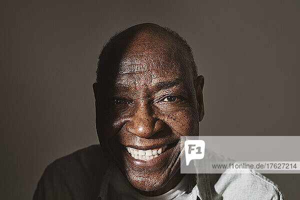 Porträt eines lächelnden älteren Mannes vor weißem Hintergrund