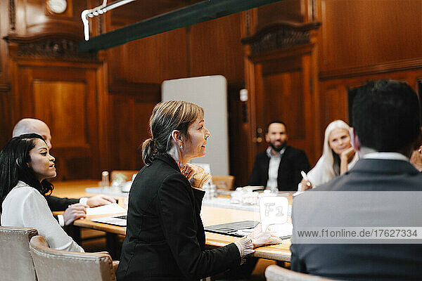 Ein Team von Anwaltskollegen diskutiert im Sitzungssaal eines Büros während einer Konferenz