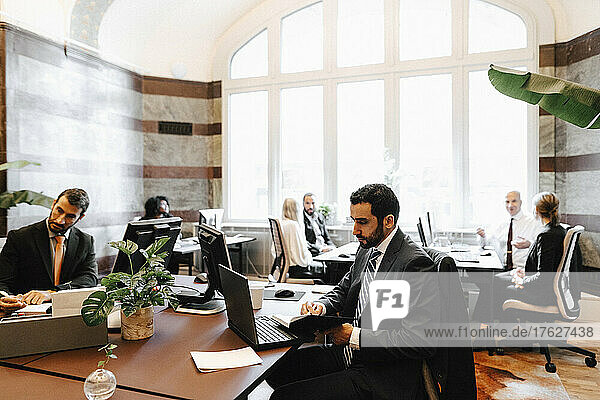 Businessmen sitting at desk working in law office