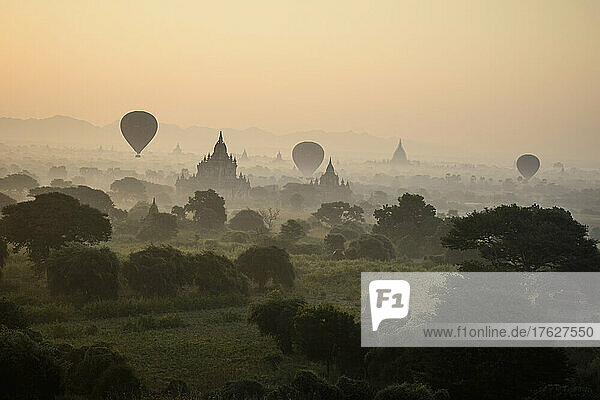 Hot air balloons hovering in the air above the plain of temples in Mandalay
