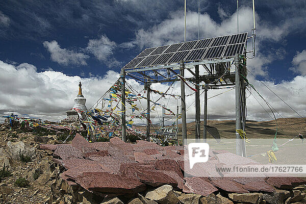 A commercial Solar Cell phone tower  mani stones and prayers flags and a small stupa or Buddhist temple