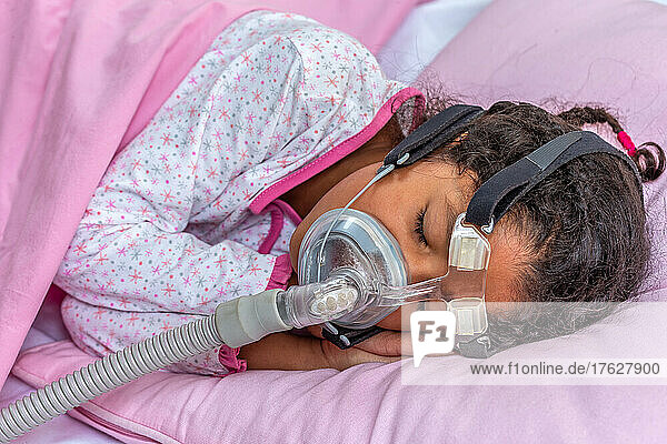 Child suffering from Sleep Apnea  using a CPAP machine