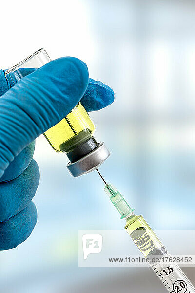 Gloved hands holding a syringe while loading a dose. Concepts of medical treatment  epidemic or vaccine