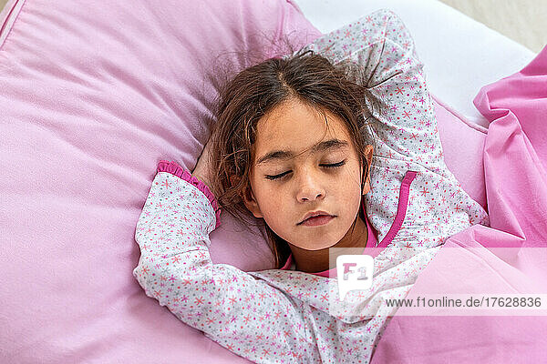 Sleeping beauty. Beautiful girl lying with t in her hand. Close-up portrait of sleeping 10 years girl. Cute . Child portrait in pastel tones. Top view.