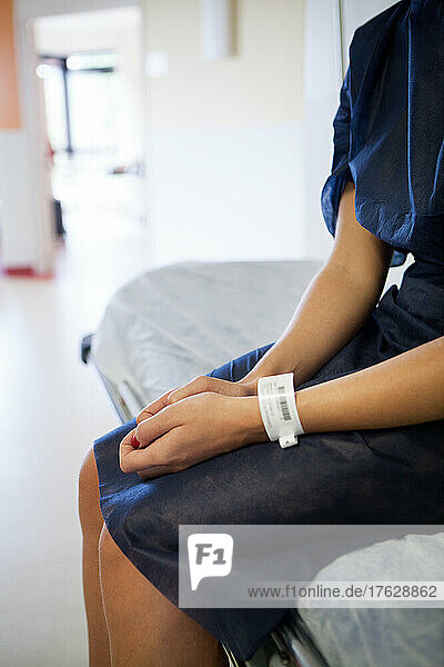 Patient on a stretcher with an identification bracelet in the outpatient surgery department.