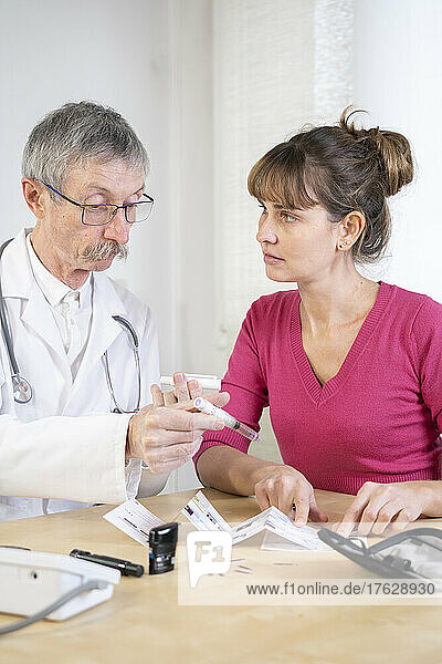 Diabetologist teaching a diabetic woman to use the tools to treat her diabetes.
