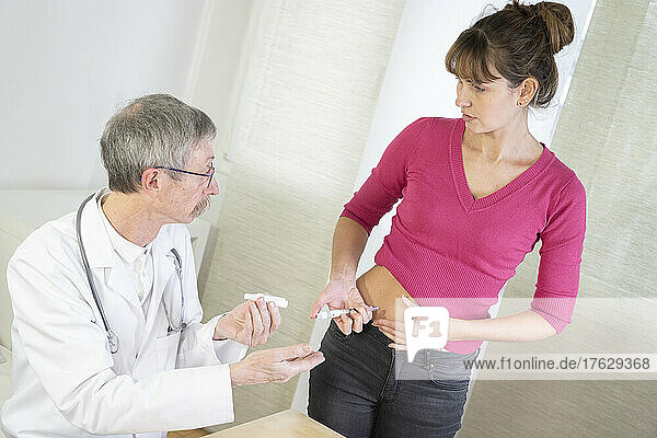 Diabetologist teaching a diabetic woman to use the tools to treat her diabetes.