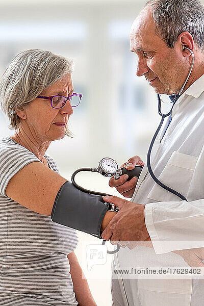 Doctor taking blood pressure from a senior.