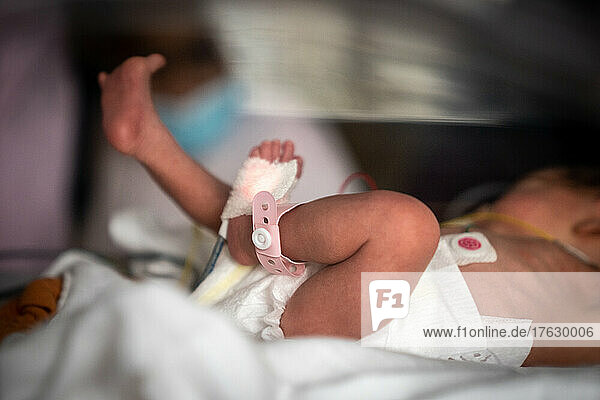 A mother participates in the care of her premature newborn baby.