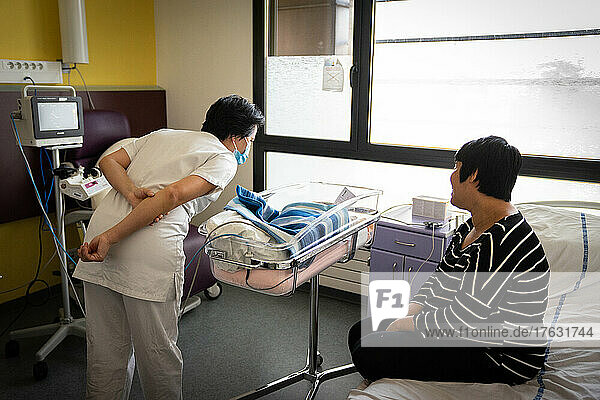 Mother and midwife taking care of the newborn in a hospital center.