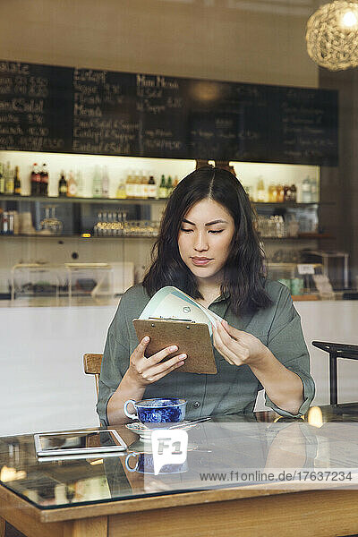 Woman looking at menu in cafe