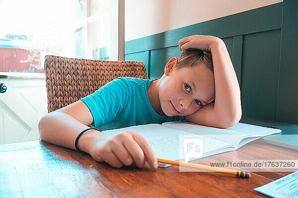 Portrait of boy doing homework at table