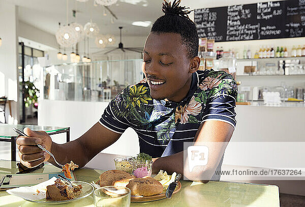 Smiling man enjoying breakfast in cafe