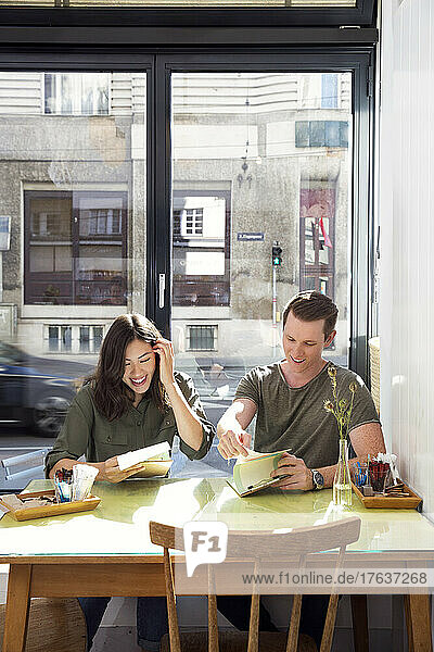 Smiling couple looking at menu at restaurant table