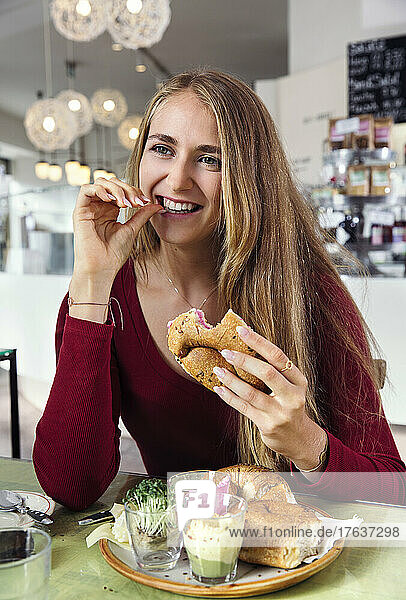 Smiling woman enjoying breakfast in restaurant