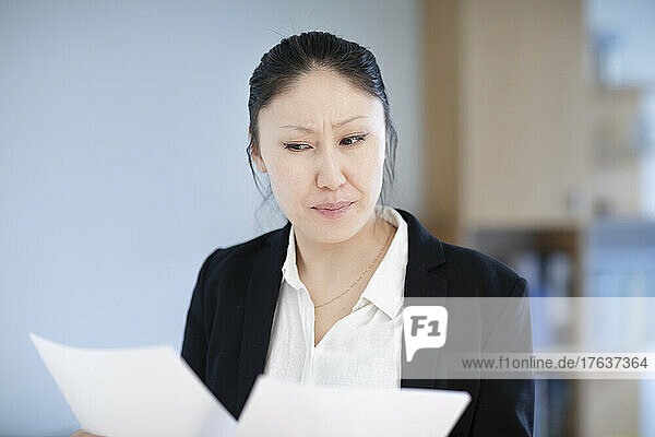Businesswoman looking atÊdocuments in office