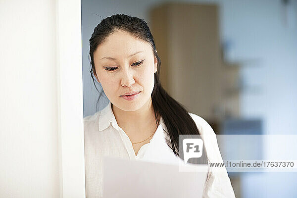 Serious businesswoman looking at documents in office
