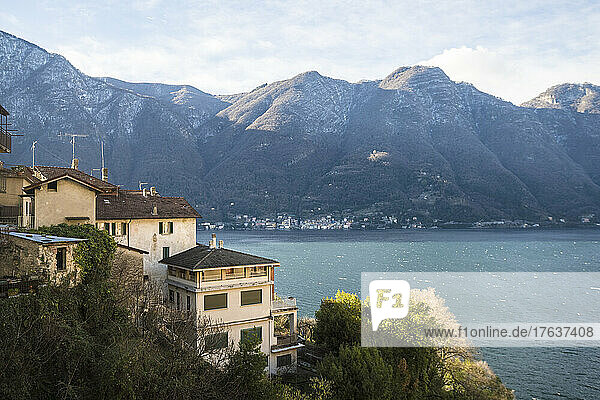 Italy  Como  Houses by lake Como with Alps in background