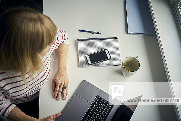 Woman sitting at desk and working from home