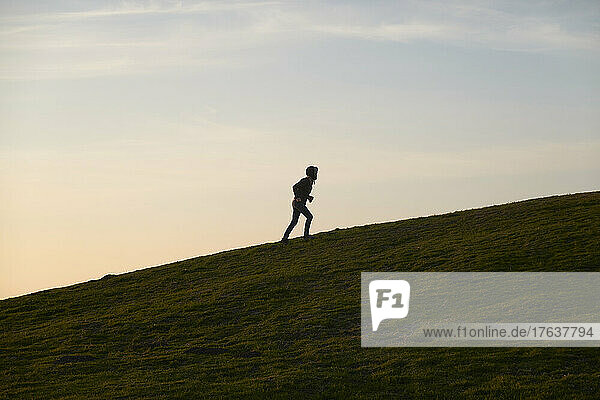 Mature woman jogging up hill