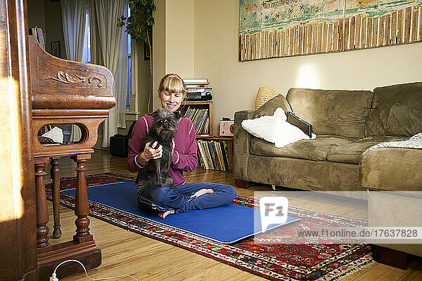 Woman meditating at home with dog