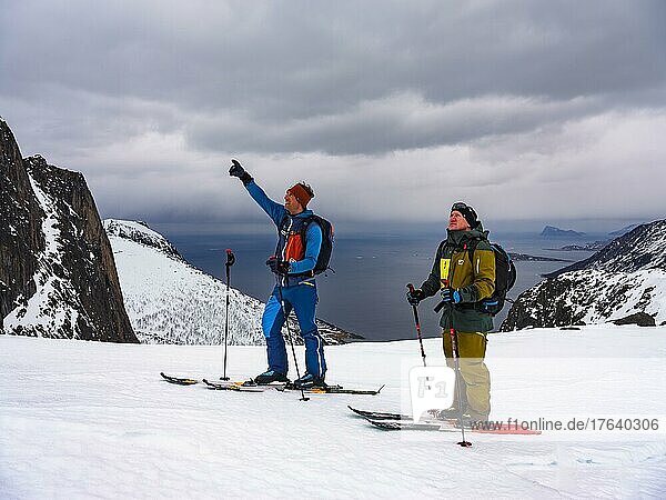 Mountain guide shows his guest the way ahead  ski tour on Senja Island  Troms  Norway  Europe