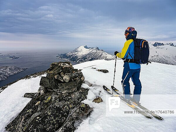 Ski mountaineers at the summit of Flobjörn with a view over the Bergsfjord  Senja Island  Troms  Norway  Europe