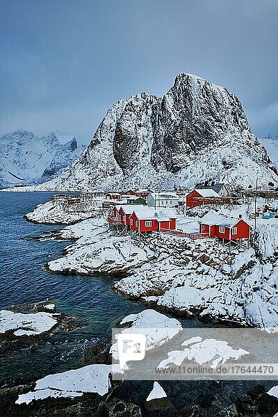 Iconic Hamnoy fishing village on Lofoten Islands  Norway with red rorbu houses. With falling snow in winter