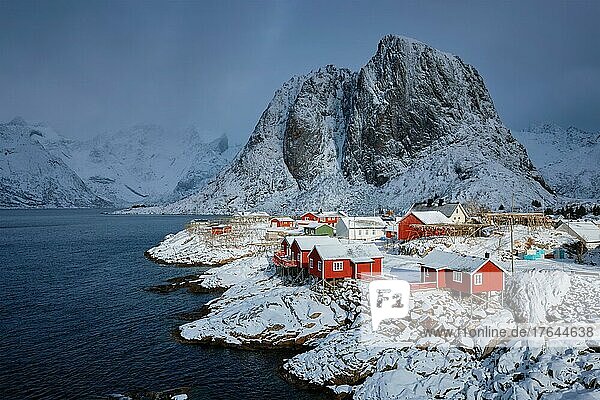 Iconic Hamnoy fishing village on Lofoten Islands  Norway with red rorbu houses  With falling snow in winter