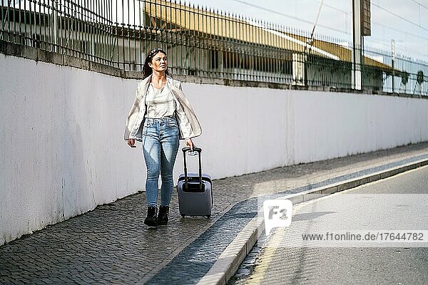 Portrait of traveling woman with luggage in urban settings