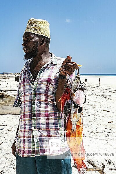 Fischer am Strand von Matemwe mit Fang  Fische  Nordostküste Unguja  Sansibar  Tansania  Afrika