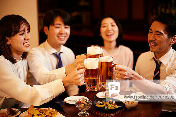 Japanese businesspeople having drinks and dining at a bar