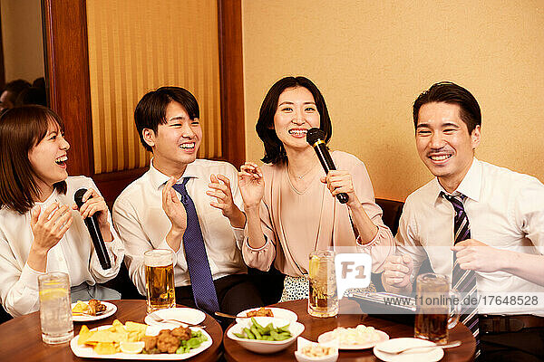 Japanese businesspeople having drinks at karaoke