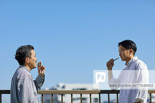 Japanese men smoking outside