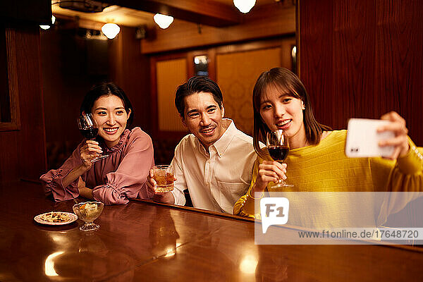 Japanese friends having a drink at a bar counter