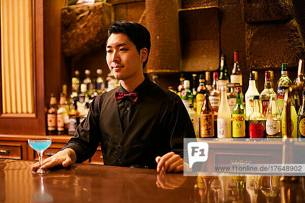 Japanese bartender serving a drink