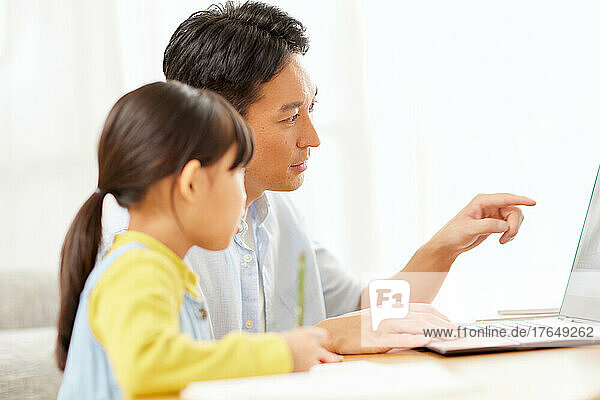Japanese kid studying at home with her parents