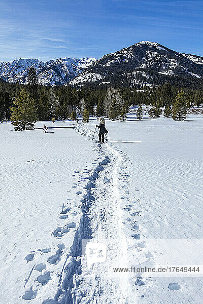 United States  Idaho  Ketchum  Rear view of senior blonde woman snowshoeing near Sun Valley in winter