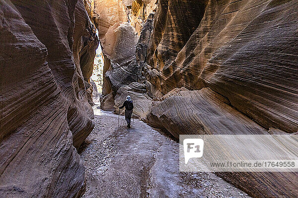 United States  Utah  Escalante  Rear view of senior female hiker exploring slot canyon in Grand Staircase Escalante National Monument in winter