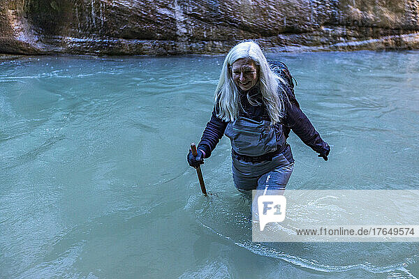 United States  Utah  Zion National Park  Senior female hiker wading The Narrows of Virgin River in Zion National Park