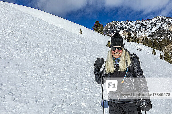 United States  Idaho  Ketchum  Portrait of smiling senior woman snowshoeing near Sun Valley on sunny winter day