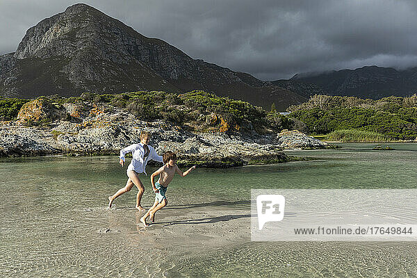 South Africa  Hermanus  Children (8-9  16-17) running at beach